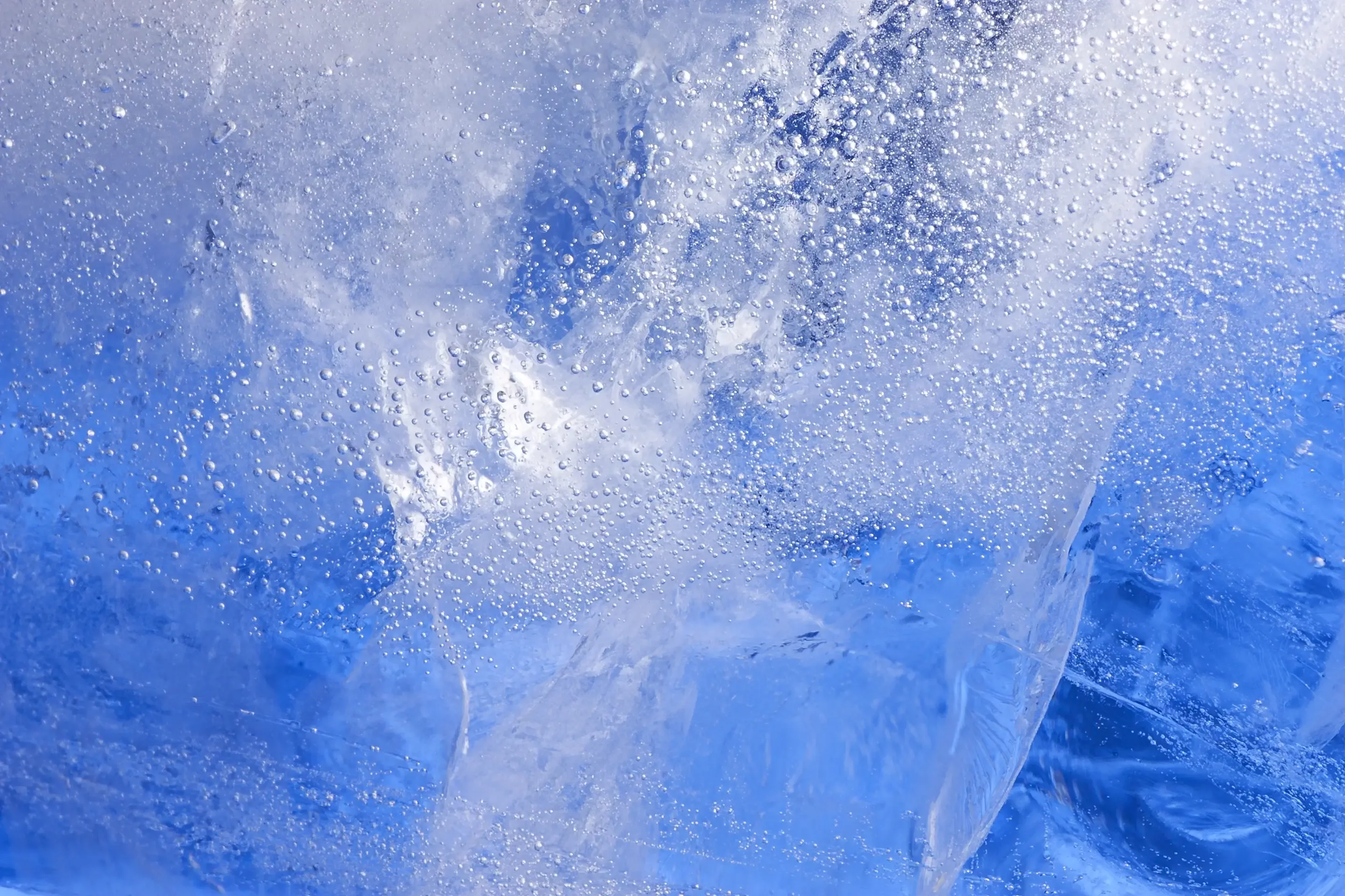 Close-up of ice with air bubbles trapped inside, creating a textured pattern.
